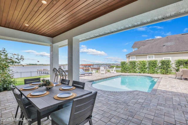 view of pool featuring a water view and a patio area