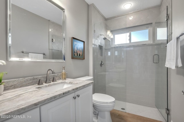 bathroom featuring vanity, toilet, and a shower with door