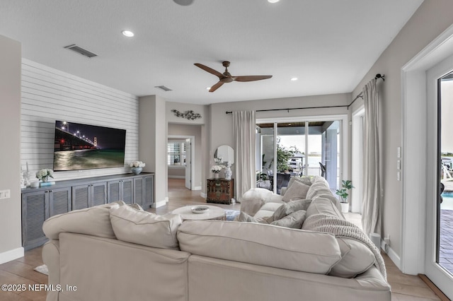 living room featuring light hardwood / wood-style flooring and ceiling fan