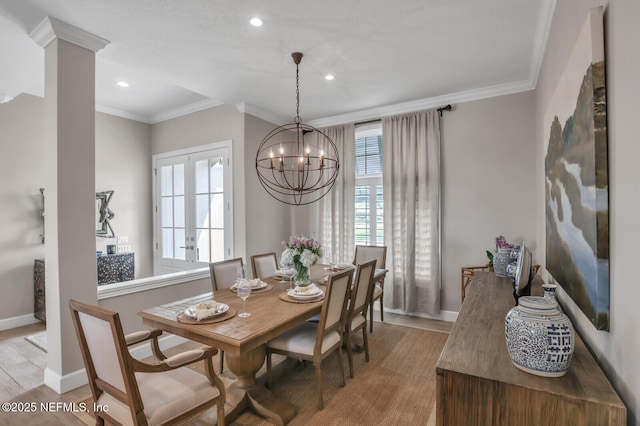 dining area featuring crown molding, a chandelier, and light wood-type flooring