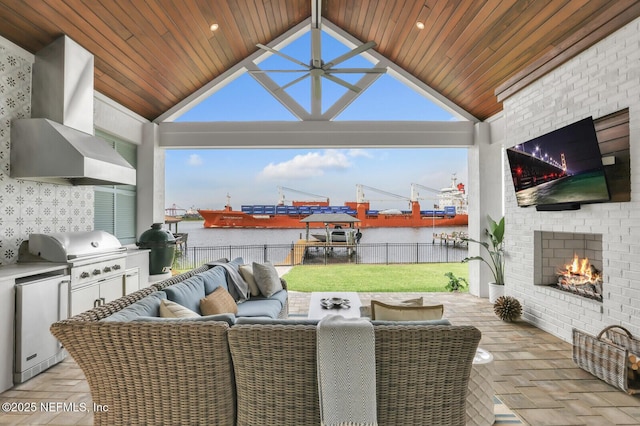 view of patio featuring area for grilling, an outdoor living space with a fireplace, and exterior kitchen