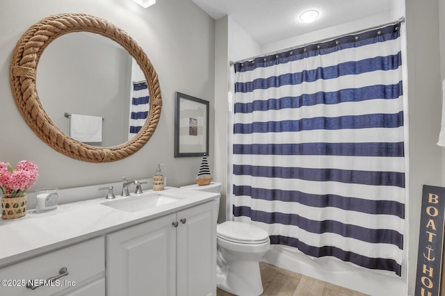 bathroom with a shower with curtain, vanity, toilet, and a textured ceiling