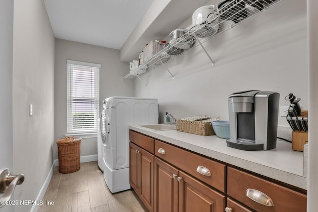 laundry room with washer / clothes dryer, plenty of natural light, sink, and light wood-type flooring