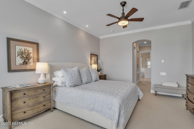 carpeted bedroom featuring ornamental molding, ceiling fan, and ensuite bath