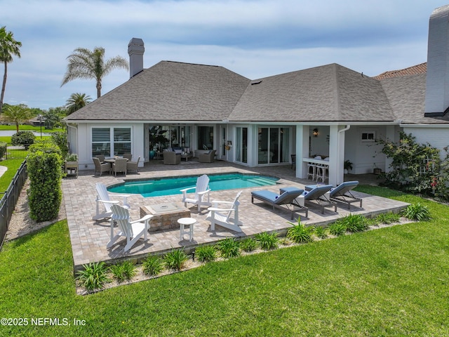 view of pool featuring a patio, a yard, and an outdoor living space with a fire pit