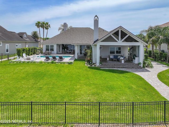 rear view of house with a fenced in pool, an outdoor living space, a patio area, and a yard