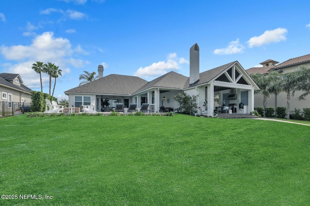 back of house with a patio and a lawn