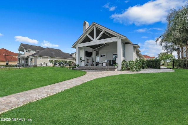 rear view of house featuring a yard and ceiling fan