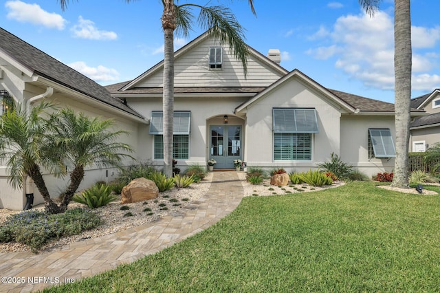 view of front of house with french doors and a front lawn