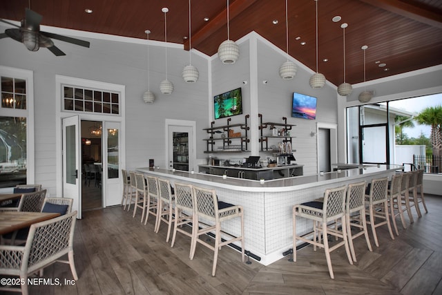 kitchen with pendant lighting, a breakfast bar area, ceiling fan, high vaulted ceiling, and wooden ceiling