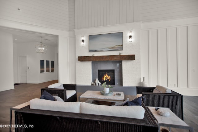 living room featuring a notable chandelier, a fireplace, and a high ceiling