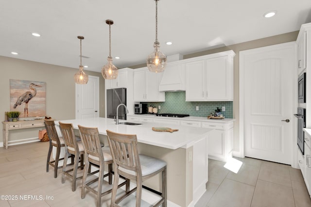 kitchen featuring hanging light fixtures, sink, a center island with sink, and stainless steel appliances