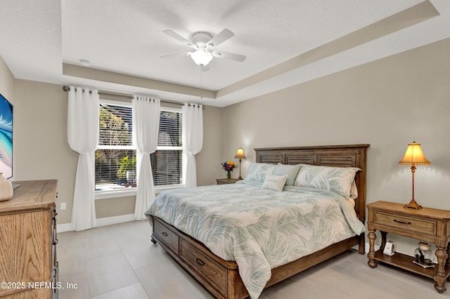 bedroom featuring a raised ceiling and ceiling fan