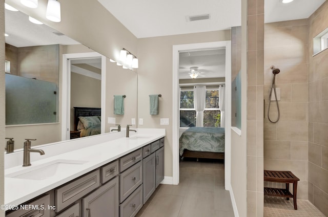 bathroom featuring ceiling fan, vanity, and a tile shower