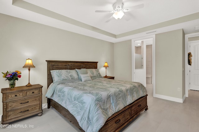 bedroom with ensuite bath and a tray ceiling