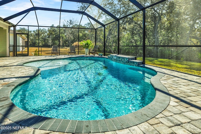 view of swimming pool with a patio and glass enclosure