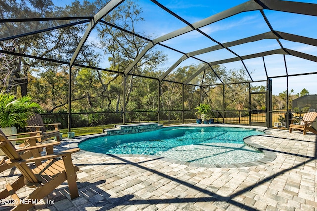 view of swimming pool featuring a jacuzzi, a patio, and glass enclosure