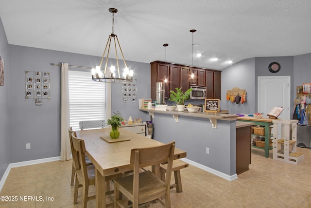 dining room with vaulted ceiling and a textured ceiling