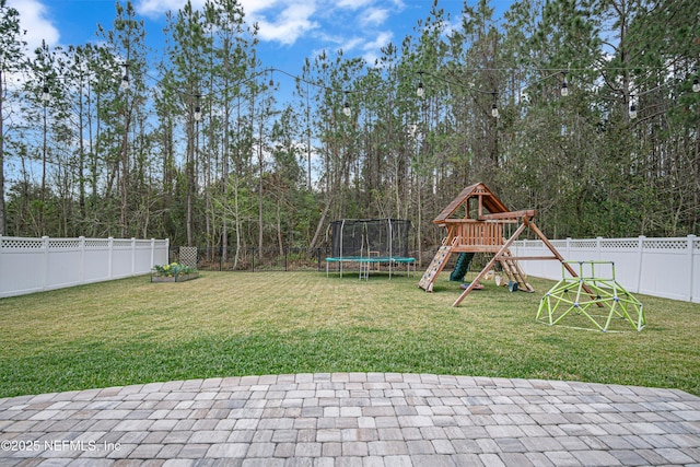 view of yard featuring a patio, a playground, and a trampoline