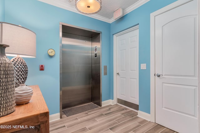 bathroom featuring elevator, ornamental molding, and a textured ceiling