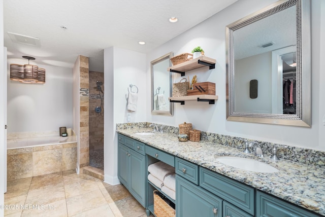 bathroom with vanity, separate shower and tub, and a textured ceiling