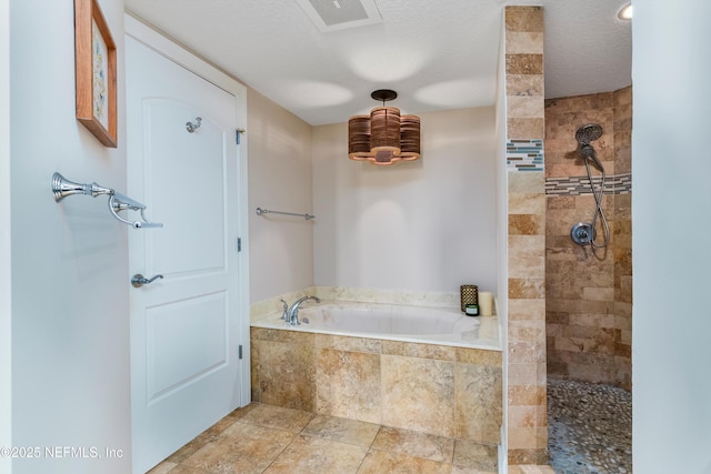 bathroom with independent shower and bath and a textured ceiling