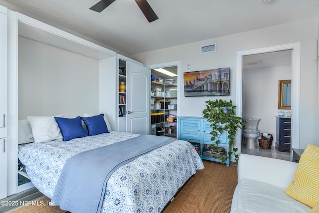 bedroom featuring dark wood-type flooring, ceiling fan, and a textured ceiling