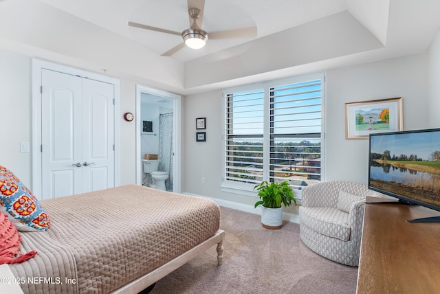 bedroom featuring ensuite bathroom, carpet, ceiling fan, and a tray ceiling