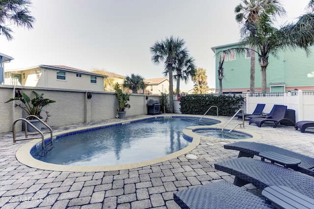 view of swimming pool featuring an in ground hot tub, a grill, and a patio