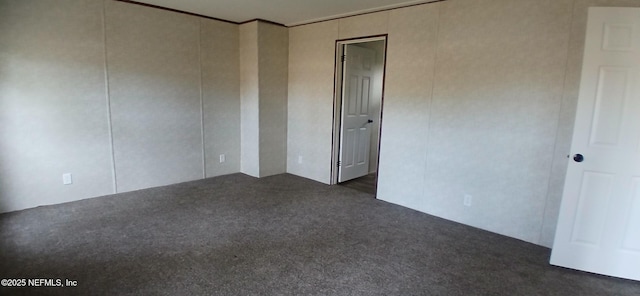 unfurnished room with dark carpet