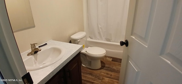 full bathroom featuring hardwood / wood-style flooring, shower / tub combo with curtain, vanity, and toilet