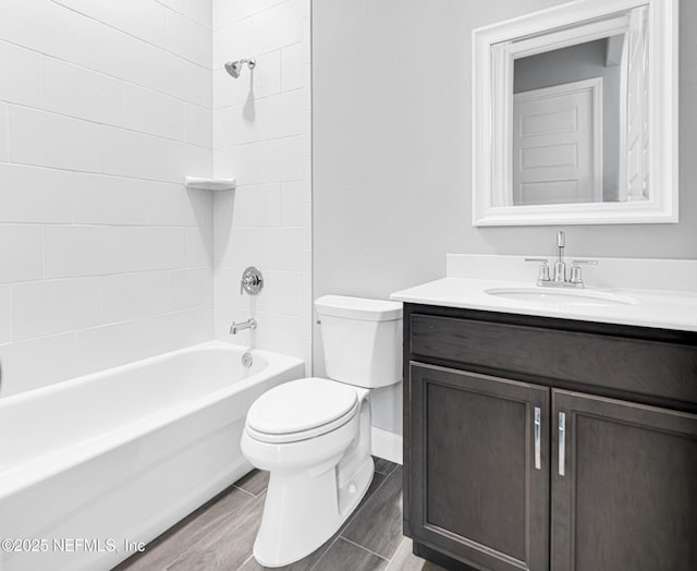 full bathroom featuring tiled shower / bath, vanity, and toilet