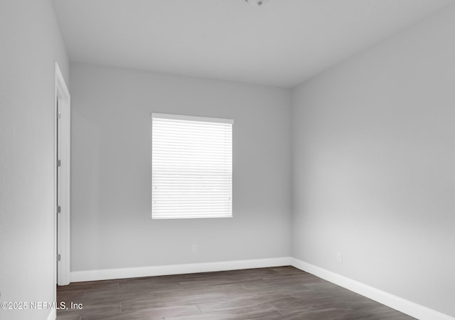 unfurnished room with plenty of natural light and dark hardwood / wood-style floors