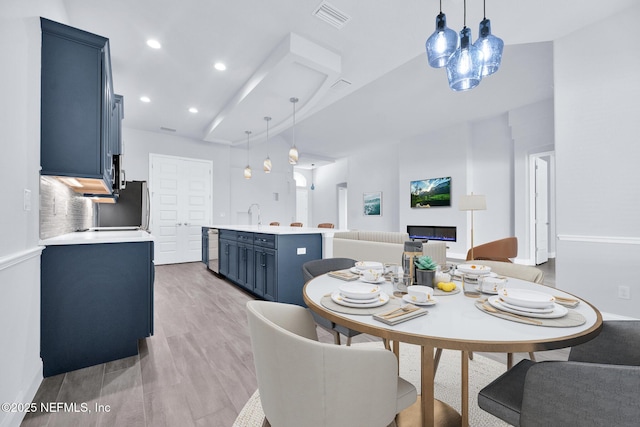 dining area featuring beam ceiling and light hardwood / wood-style flooring