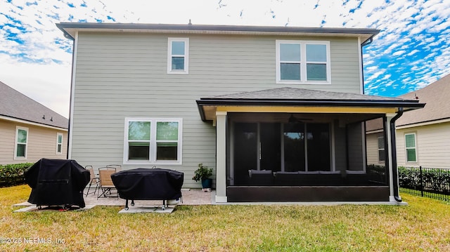 back of house with a lawn, a sunroom, and a patio area