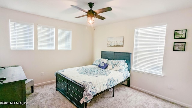 carpeted bedroom with multiple windows and ceiling fan