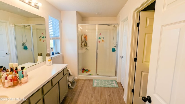 bathroom with hardwood / wood-style flooring, vanity, and an enclosed shower