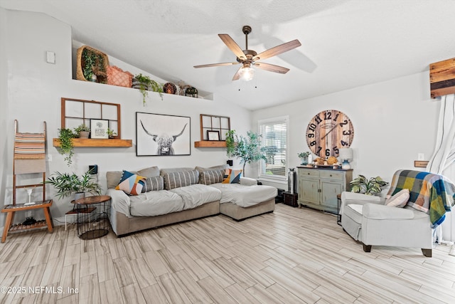 living room featuring ceiling fan, lofted ceiling, a textured ceiling, and light hardwood / wood-style flooring