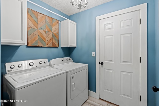 washroom with cabinets, washing machine and clothes dryer, and a textured ceiling