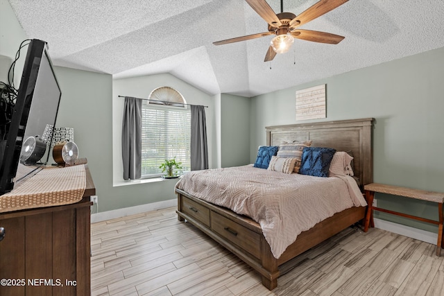 bedroom featuring ceiling fan, vaulted ceiling, light hardwood / wood-style flooring, and a textured ceiling