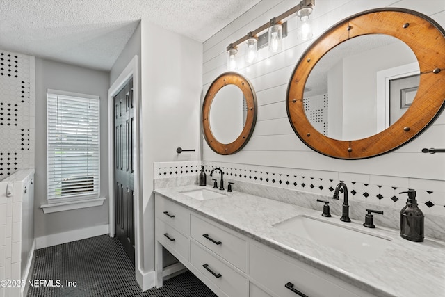 bathroom with vanity, tile patterned flooring, decorative backsplash, and a textured ceiling