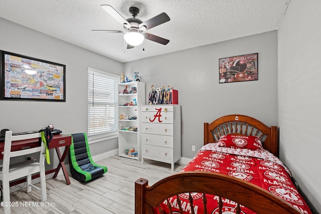 bedroom featuring ceiling fan, a textured ceiling, and light hardwood / wood-style flooring