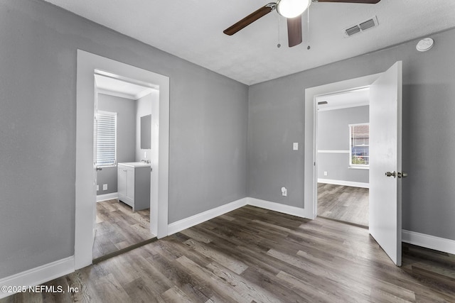 unfurnished room featuring hardwood / wood-style flooring, ornamental molding, sink, and ceiling fan