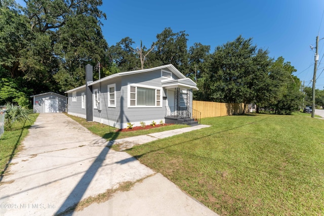 view of front of home with a front yard and a storage unit