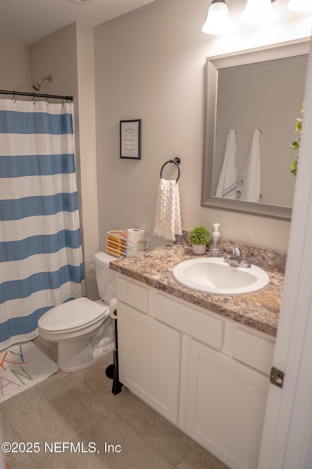 bathroom featuring tile patterned floors, toilet, a shower with curtain, a textured ceiling, and vanity