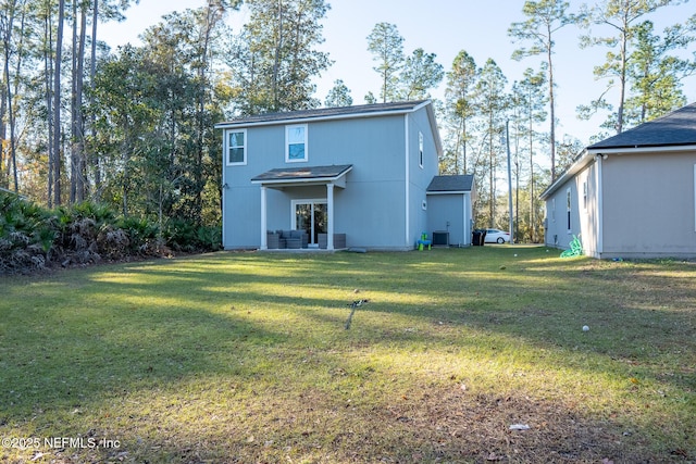 rear view of property featuring cooling unit and a yard