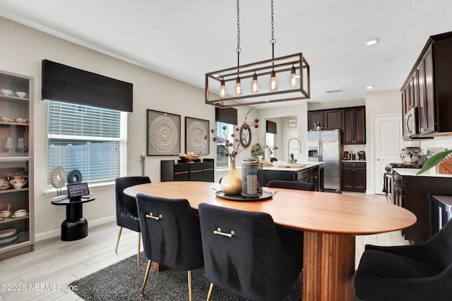 dining area featuring sink and light wood-type flooring