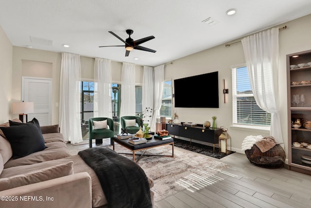 living room with light hardwood / wood-style flooring and ceiling fan