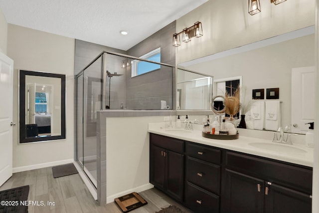 bathroom with hardwood / wood-style flooring, vanity, and a shower with door