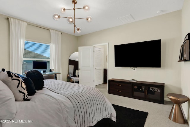 carpeted bedroom with a chandelier